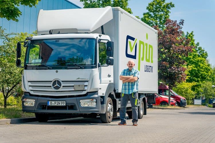 Mann neben PIN Logistik LKW, Effizienz in Kurierdiensten